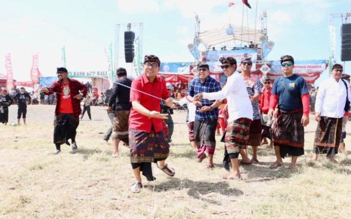 Wakil Wali Kota Denpasar I Kadek Agus Arya Wibawa saat ikut berbaur menarik tali layangan dengan peserta lomba dalam Festival Layangan Bali di Pantai Padang Galak, Denpasar, Minggu (23/7/2023).(foto: ant)