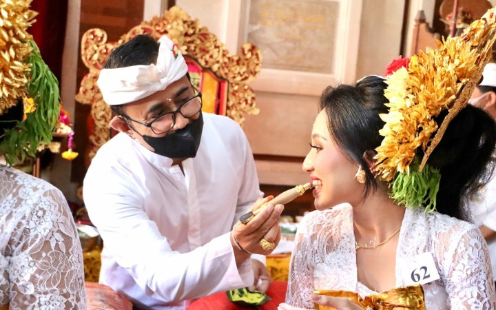 Wali Kota Denpasar turut menatah gigi salah satu peserta Mapandes atau potong gigi massal di Sanur Kauh, Jumat (29/7).
