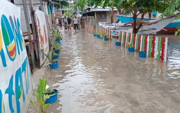 Suasana air laut saat pasang tinggi meluber ke jalan dan masuk ke rumah warga di Pulau Kodingareng, Kecamatan Sangkarrang, Makassar, Sulawesi Selatan