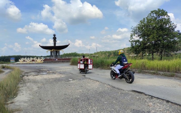Pengguna motor sedang melintasi jalan rusak yang berada di Jalan Terusan Endro Suratmin, akses utama ke Desa Sabah Balau, Lampung Selatan. (ant)