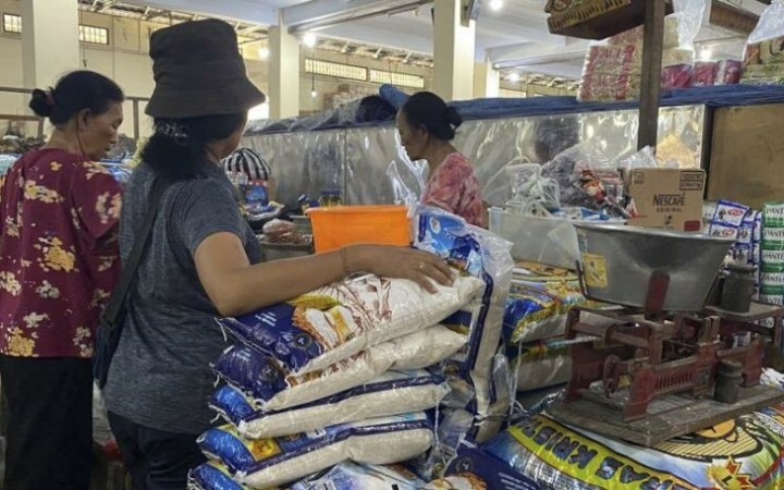 Pedangan beras Ni Wayan Binder melayani konsumen di kiosnya di Pasar Kusama, Kabupaten Klungkung, Bali, Selasa