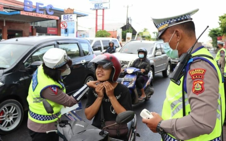 Personel Satuan Lalu Lintas Kepolisian Resor Kota Denpasar sedang memberikan edukasi kepada masyarakat pengendara motor tentang tertib berkendara dalam Operasi Keselamatan Agung 2023 di salah satu ruas jalan di Kota Denpasar, Bali, Senin