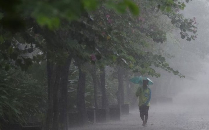 Ilustrasi - seorang pria sedang berjalan di tengah derasnya hujan. (foto:net)