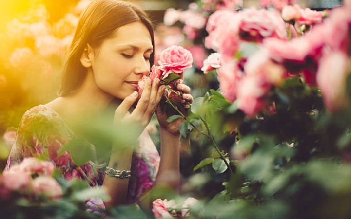 Ilustrasi- Seorang wanita mencium aroma bunga mawar di taman (foto: gemapos/istock)