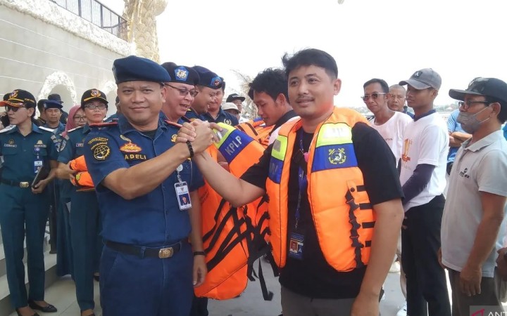 Kepala KSOP Kelas II Benoa, Bali, Sadeli (kiri) menyerahkan jaket keselamatan kepada perwakilan operator kapal cepat yang beroperasi di Pelabuhan Sanur, Denpasar, Kamis (9/11/2023). (foto: gemabali/ antara)