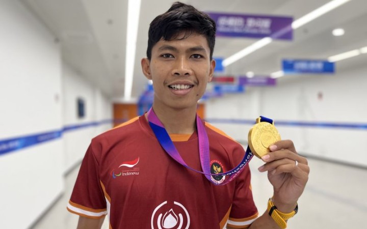 Pelari Indonesia Saptoyogo Purnomo berpose dengan medali emas yang ia dapatkan di Asian Para Games 2022 Hangzhou, di Huanglong Sports Centre Stadium, China, Kamis (26/10/2023). (gemapos/ant)