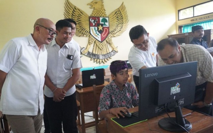 Senior Manager Komunikasi & Umum PT PLN (Persero) Unit Induk Distribusi Bali Krisantus Hendro Setyawan (kedua dari kanan) berserta rombongan PT PLN UID Bali memperlihatkan beberapa perangkat komputer yang diberikan kepada anak-anak kurang mampu