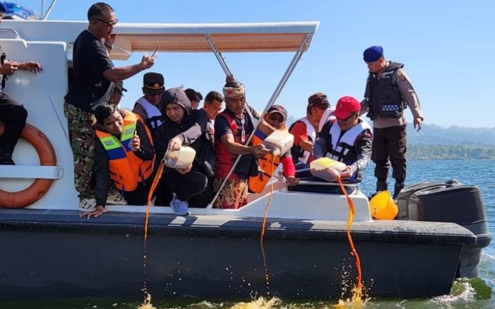 Bupati Bangli Sedana Arta dan para pejabat di lingkungan Pemkab Bangli menebar ikan nila dan menuang Eco enzim di Danau Batur, propinsi Bangli (foto: gemabali/ antara)