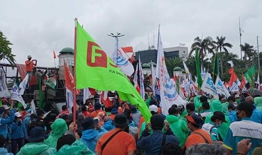 ribuan buruh tetap bertahan gelar aksi demo, mereka tampak mengenakan jas hujan yang dijajakan oleh pedagang sekitar lokasi