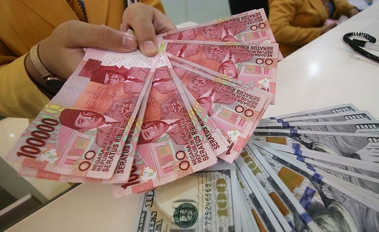 Teller Bank Mandiri menunjukkan uang pecahan Dolar AS dan Rupiah di Bank Mandiri KCP Jakarta DPR, Senin (7/1/2019). Kurs Rupiah terhadap Dolar AS menguat 1,3 persen menjadi Rp14.080. (ant)