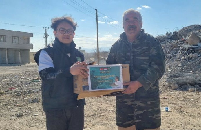 Seorang relawan menyerahkan secara simbolik bantuan dari Ketua Umum PKB Muhaimin Iskandar kepada penyintas gempa di Kota Adana, Turki, Jumat (17/2/2023). (ant)